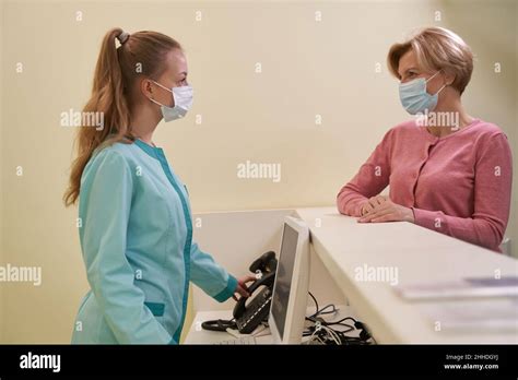Pleased Blonde Female Person Talking To Receptionist Stock Photo Alamy