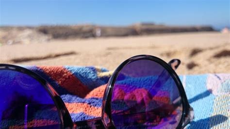 Premium Photo Sunglasses On Towel At Beach During Sunny Day