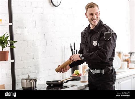 Police Officer Smiling And Cooking Breakfast At Kitchen Stock Photo Alamy