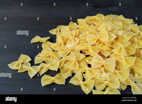 Pile Of Dried Farfalle Or Bow Tie Pasta On Black Wooden Background