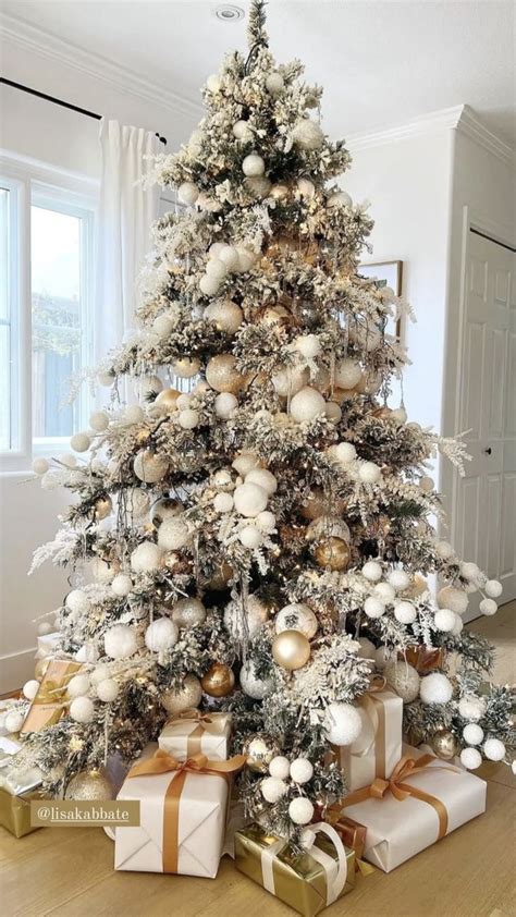 A White Christmas Tree With Gold And Silver Ornaments On It S Branches