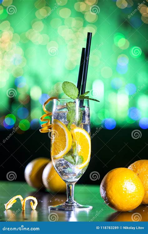 Fresh Cocktail With Orange Ice Ang Mint Leaves On Bar Lights And Green Background Stock Image