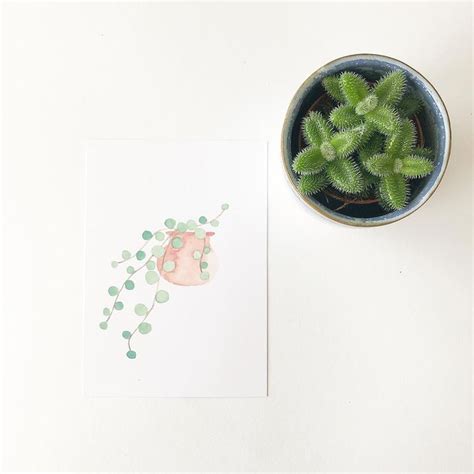 A Potted Plant Next To A Piece Of Paper With A Drawing On The Side