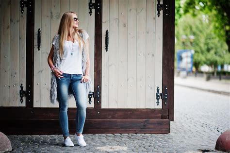 Stilvolle blonde Frauen tragen Jeans und Mädchen ärmellos mit weißem Hemd gegen Straße