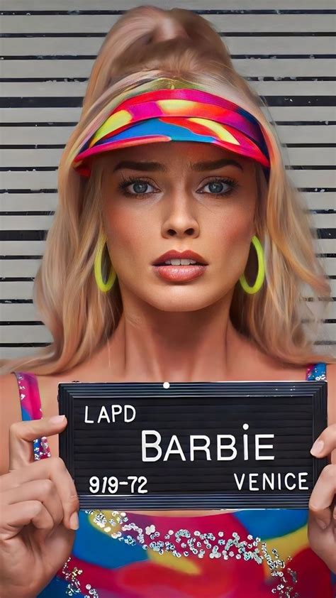 A Woman Holding Up A Sign That Says Lapd Barbie Venice On The Side Of