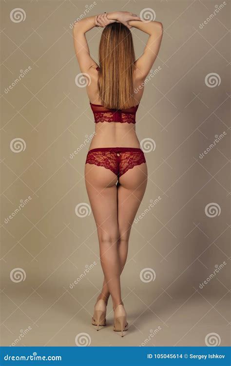 La Fille Attirante Dans La Lingerie Rouge Se Tient Avec Elle De Retour