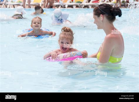 A Mother And Two Daughters Are Swimming In A Public Pool Daughters Of