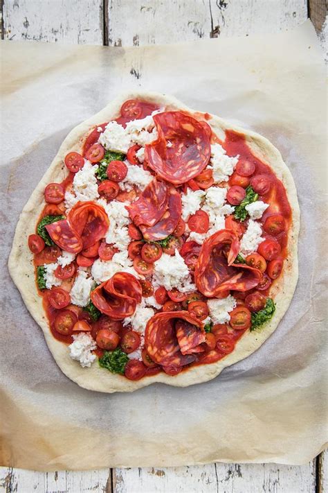 An Unbaked Pizza With Tomatoes And Salami Photograph By Magdalena