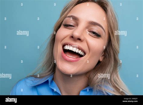 Stylish Casual Blonde Girl Flirts And Smiles On A Blue Isolated Background Stock Photo Alamy