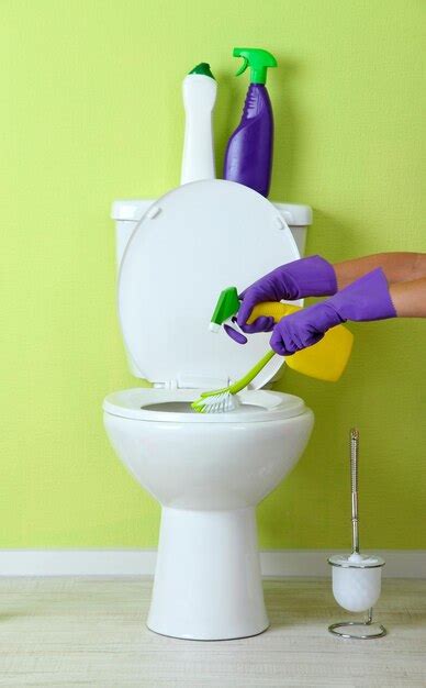 Premium Photo Woman Hand With Spray Bottle Cleaning A Toilet Bowl In