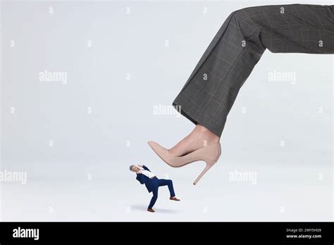 Big woman stepping onto small man on white background Stock Photo - Alamy