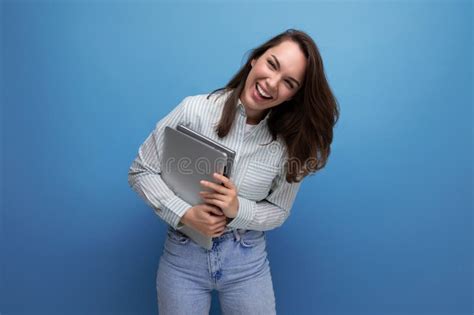 It Specialist Year Old Brunette Woman In Shirt And Jeans Enjoys Freelancing Holding A Laptop