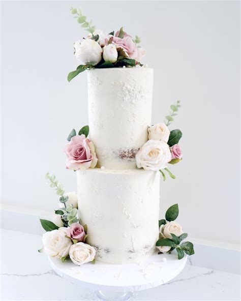 Two Tier White Semi Naked Ganache Wedding Cake With Artificial Flowers The Baked Studio The