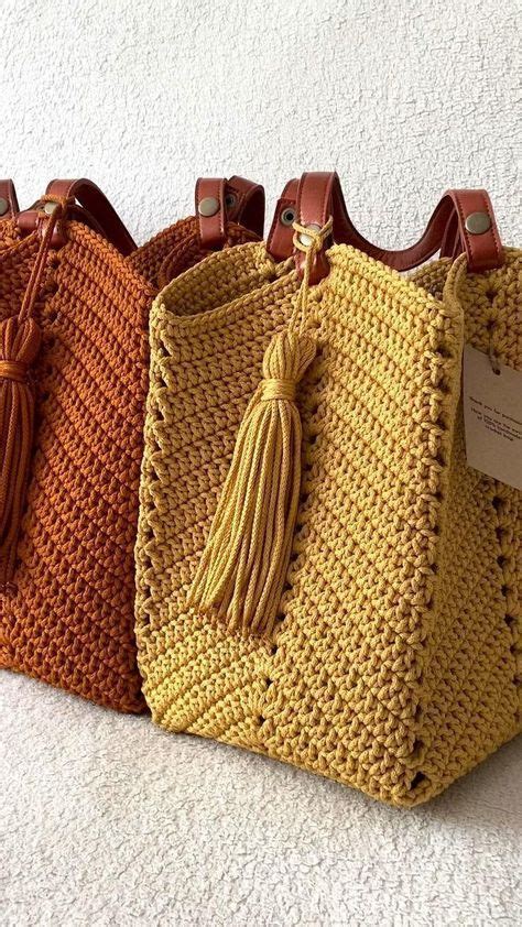 Three Crocheted Handbags With Tassels On The Handles Are Lined Up