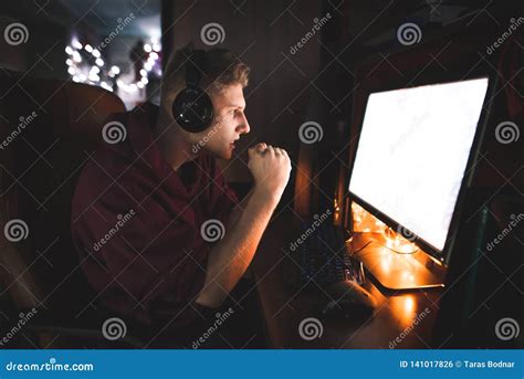 Focused Gamer Looks At The Computer Screen Watching The Game And