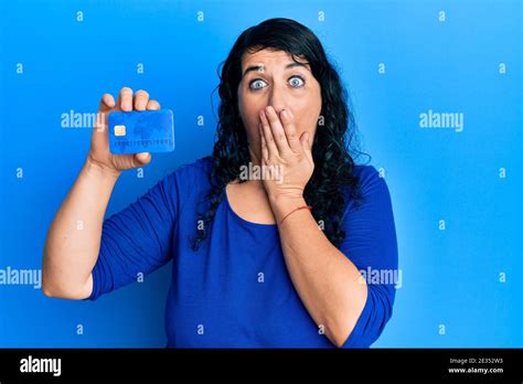 Plus Size Brunette Woman Holding Credit Card Covering Mouth With Hand