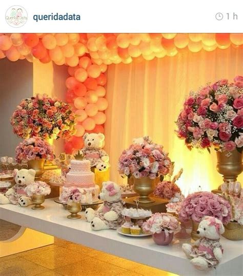 A Table Topped With Lots Of Pink And White Flowers Next To Tall Vases