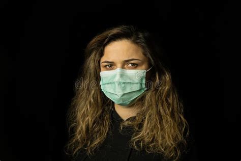 Studio Portrait Of Young Woman Wearing A Face Mask Looking At Camera