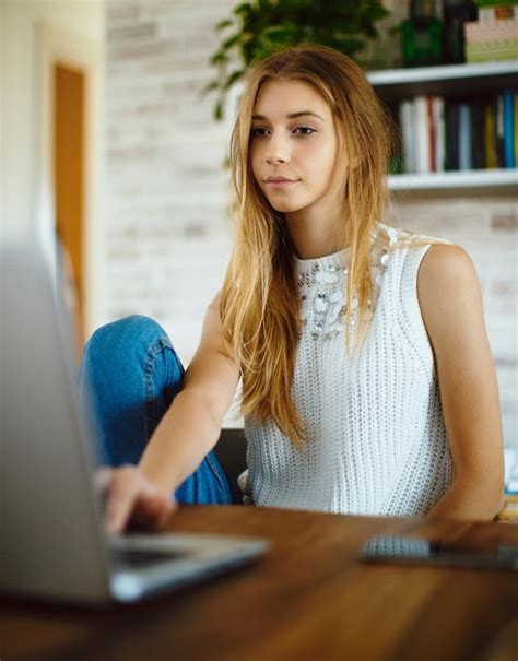 Premium Photo Young Woman Using Laptop While Sitting At Home