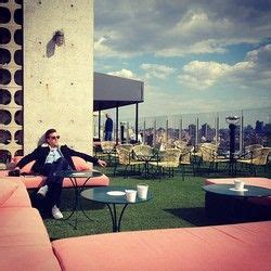 A Man Sitting On Top Of A Pink Couch In Front Of A Tall Building With