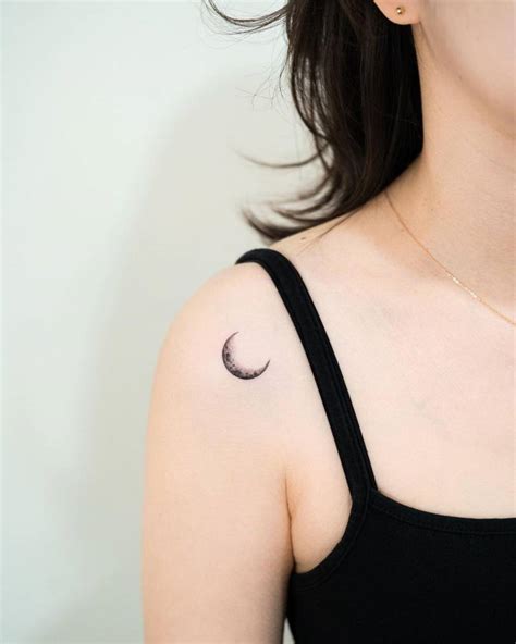 Micro-realistic style crescent moon tattoo located on