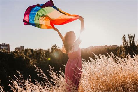 Premium Photo Woman Holding Rainbow Flag While Standing On Field