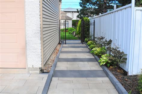 Un trottoir du côté de la maison avec insertion de couleur différente