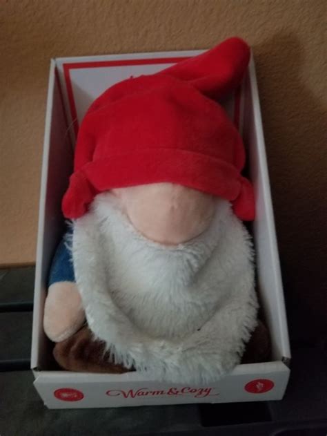 A Stuffed Toy In A Box With A Red Hat And Beard On Its Head