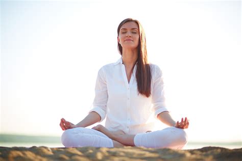 Woman Sitting By The Ocean With Beautiful Lighting In Meditation