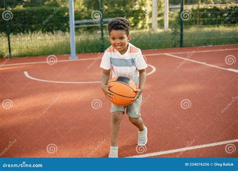 Garçon Multiracial Debout Sur Un Terrain De Basket Et Jouer Avec Une