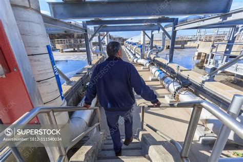 Engineer Walking Through Water Treatment Plant Superstock