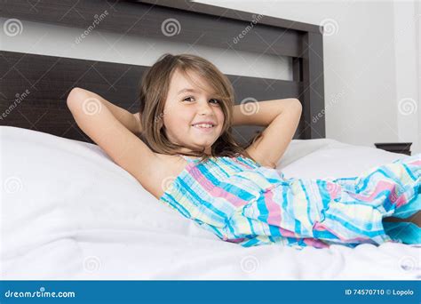 Portrait De La Belle Petite Fille Se Trouvant Sur Le Lit Photo Stock