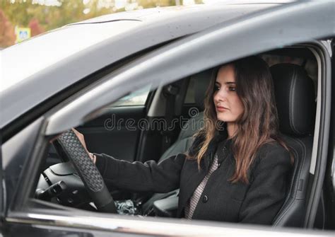 Side View Of Brunette Woman Starting A Car Wearing Coat Luxury
