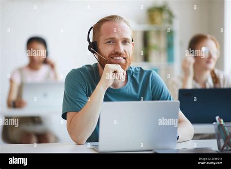 Portrait d un homme barbu mature dans un casque souriant à l appareil photo tout en travaillant