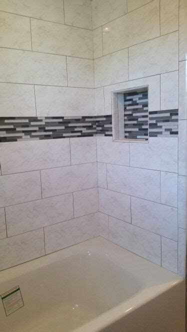 White And Gray Wall Tiles Installed In A Subway Pattern With Glass