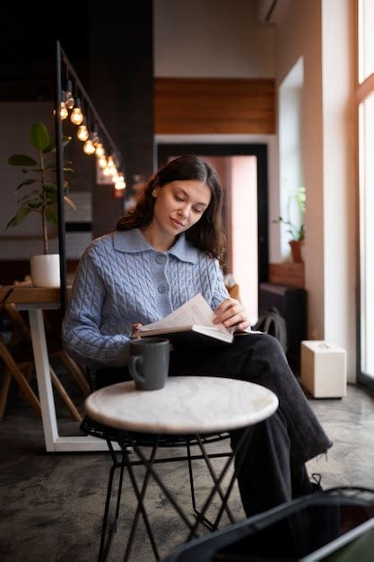 Free Photo | Person in a cafe reading a book while having coffee