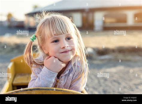 Liebenswert niedlich kaukasischen blonde Kind Mädchen Porträt sitzt in Holzwagen Blick beiseite
