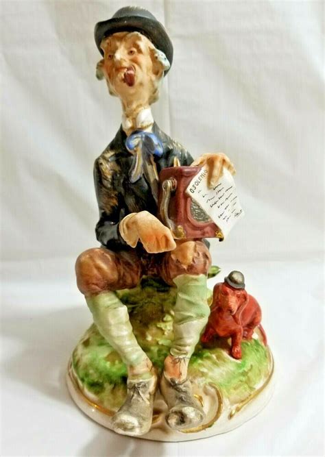 A Figurine Of A Man Sitting On Top Of A Table