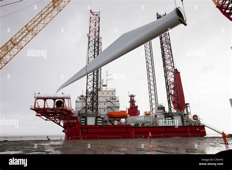 Wind Turbine Blades Being Lifted Onto A Jack Up Barge To Construct The