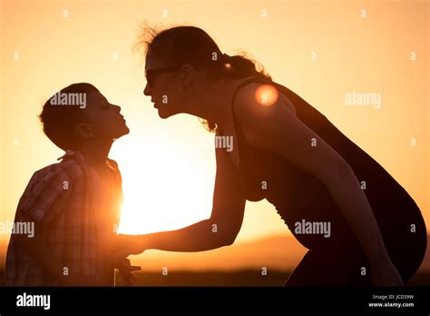 Mother And Son Walking On The Field At The Sunset Time People Having