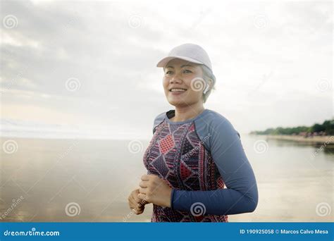 Fit And Happy Middle Aged Woman Running On The Beach S Or S Attractive Mature Lady With