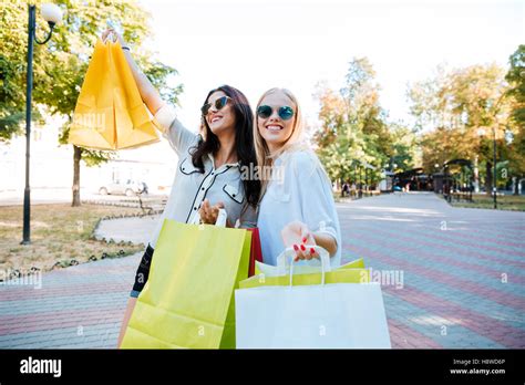 Two Beautiful Young Women With Shopping Bags Walking In The Ctiy Stock