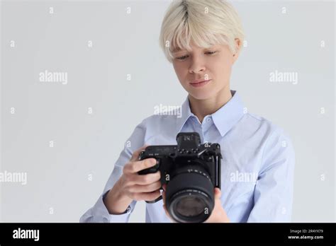 Short Haired Blonde Woman Adjusts Digital Photo Camera Stock Photo Alamy