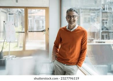 Smiling Mature Businessman Leaning Glass Window Stock Photo