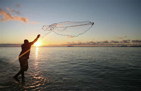 Fisherman Casting His Net At Sunset By Reniw Imagery