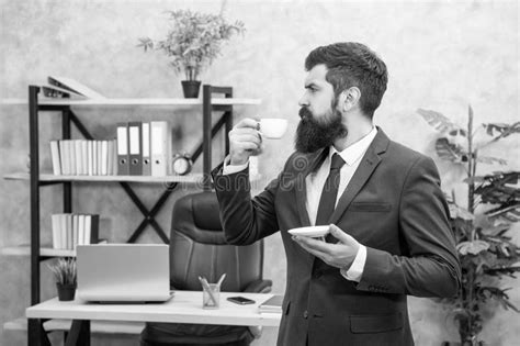 Serious Brutal Ceo In Businesslike Suit Hold Morning Coffee Cup At The
