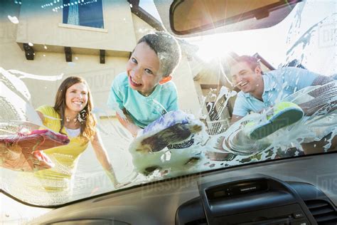 Caucasian Father And Children Washing Car Windshield Stock Photo