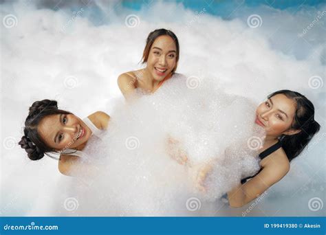 Asian Women Friends Enjoy Playing Together In Foam Bobbles Pool Party