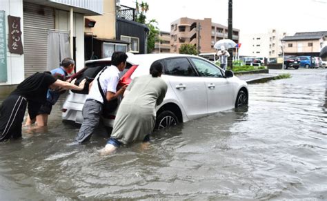 冠水した車を協力して移動させる近隣住民ら＝3日、福岡県久留米市東櫛原町（写真の一部を加工しています。撮影・玉置采也加） 九州で激しい雨