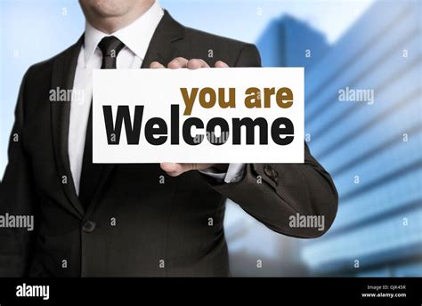 you are welcome sign is held by businessman Stock Photo - Alamy